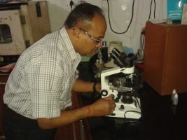 Dr. Raj Kumar Singh operating fully automatic blood testing analyzer for accurate results in Kotdwar