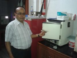 Dr. Raj Kumar Singh analyzing blood sample on modern pathology machine at Garhwal Lab Kotdwar
